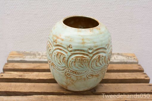 Elegant blue-green ceramic vase with embossed wave designs for stylish home decor.
