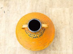 Vibrant orange pottery vessel with intricate dark patterns and sturdy handles, perfect for decor.