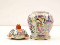 Colorful porcelain jar with lid, featuring intricate butterfly and floral designs.