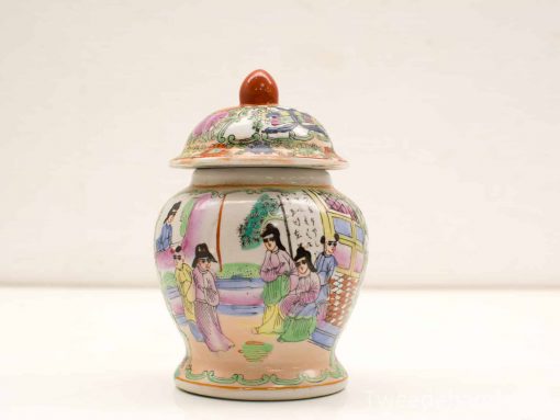 Elegant vintage porcelain jar with lid, featuring intricate scenes in soft pastel colors.