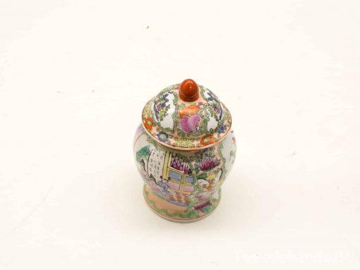 Colorful ornate ceramic jar with lid showcasing intricate floral and architectural designs.