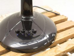 Sleek black lamp on rustic wooden table, featuring adjustable brightness settings for versatile lighting.