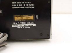 Vintage Akai AM-U41 audio amplifier featuring a sleek black design and safety labels.