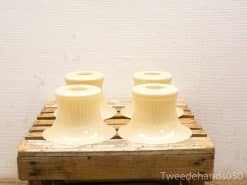 Elegant cream ceramic bell-shaped lamp shades on a rustic wooden crate.