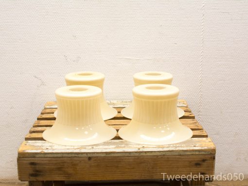 Elegant cream ceramic bell-shaped lamp shades on a rustic wooden crate.