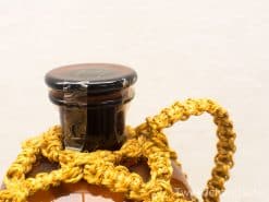Artisan amber glass bottle with wooden cap and braided cord, perfect for decoration or storage.