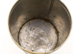 Vintage metallic cup showcasing wear, stains, and history from countless drinks over time.