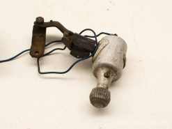 Vintage mechanical part with shiny cylinder, electrical connector, and rustic bracket, ideal for collectors.
