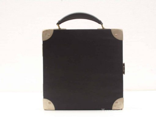 Elegant vintage black case with leather handle and metallic corners, perfect for travel or storage.