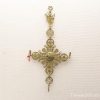Antique decorative cross with filigree, floral motifs, and candle holders for spiritual display.