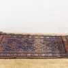 Vintage dark blue area rug with intricate geometric patterns and rich cultural heritage.