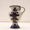Handcrafted ceramic jug featuring blue hearts and floral designs, perfect for any decor.