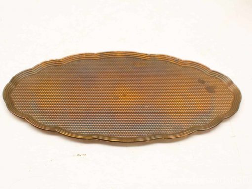 Vintage oval platter with scalloped edges and warm patina, ideal for elegant serving and decor.