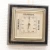 Vintage barometer with glass cover, wooden frame, and Dutch inscriptions for weather conditions.