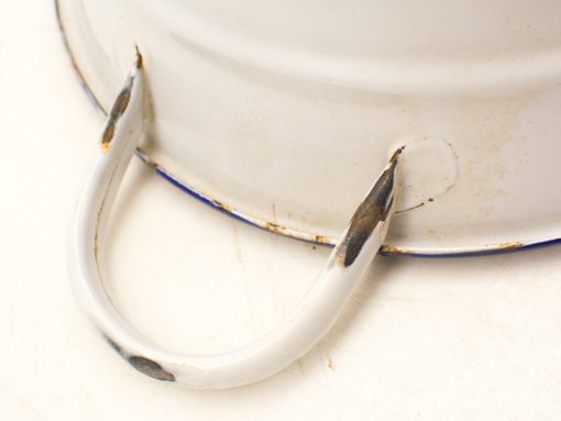 Vintage white metal container with blue rim, showing charming signs of wear and nostalgia.