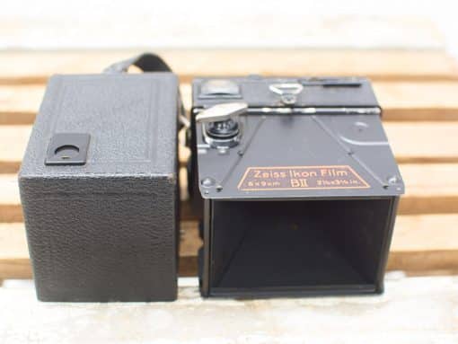Vintage Zeiss Ikon film camera with elegant design and classic black finish in leather case.