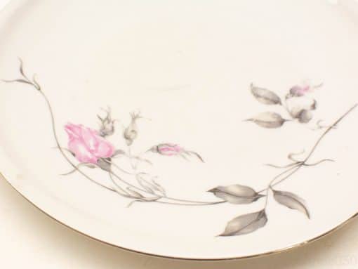 Elegant porcelain plate with floral motifs, featuring a pink rose and luxurious golden rim.