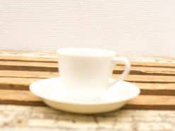 Elegant white porcelain cup and saucer for a refined coffee or tea experience.