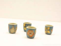 Charming handmade ceramic cups with nature motifs in soft blue, perfect for espresso or decor.