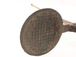 Antique cast iron waffle maker with handle, perfect for crafting unique, textured waffles.