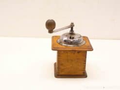 Vintage wooden coffee grinder with metal mechanism, perfect for grinding beans and adding rustic charm.