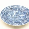 Elegant blue and white ceramic plate with nature motif, perfect for decorative use.