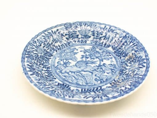 Elegant blue and white ceramic plate with nature motif, perfect for decorative use.