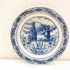 Traditional Dutch Delft plate featuring a church and windmill in classic blue and white design.