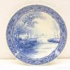 Elegant blue and white porcelain plate featuring a serene nature scene and intricate detailing.