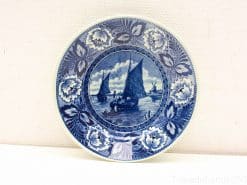 Blue and white ceramic plate featuring sailboats and floral border, perfect for display or serving.