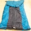 Vibrant teal and black sleeping bag for outdoor adventures, combining style, warmth, and comfort.