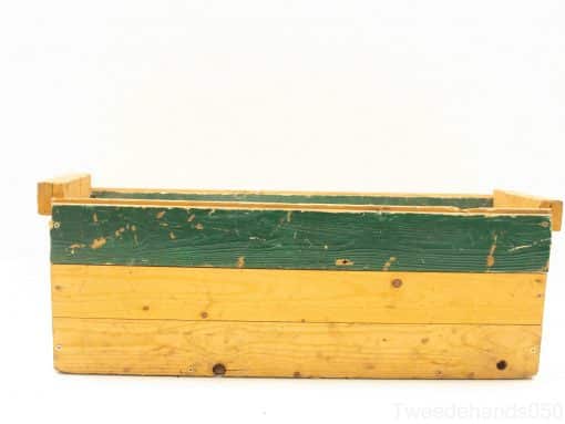 Vintage wooden crate in green and yellow, perfect for storage or rustic decor.