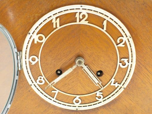 Elegant vintage wooden table clock with classic white face and warm wooden backdrop.