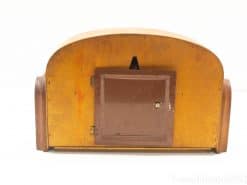 Vintage wooden cabinet with rounded top, warm finish, and charming door detail. Perfect for decor.