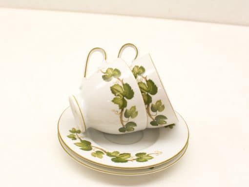Elegant vintage porcelain tea set with green leaf design and gold trim accents.