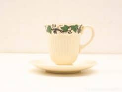 Elegant porcelain coffee cup and saucer with grape motif, perfect for any occasion.