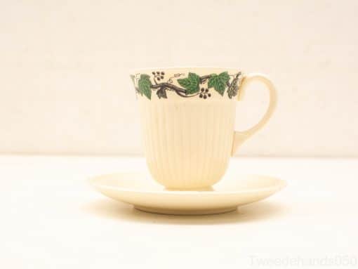 Elegant porcelain coffee cup and saucer with grape motif, perfect for any occasion.