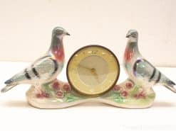 Elegant table clock with ceramic doves and floral design, perfect for vintage decor.