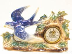 Whimsical vintage clock featuring a flying swallow and elegant nature-inspired decorations.