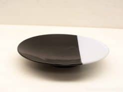 Elegant black and white plate, perfect for stylish decor and versatile serving options.