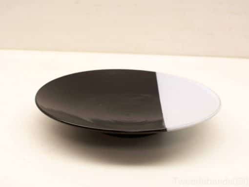 Elegant black and white plate, perfect for stylish decor and versatile serving options.
