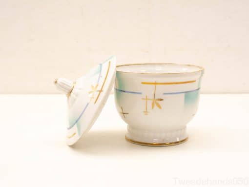 Elegant vintage porcelain container with lid, adorned with pastel colors and golden accents.