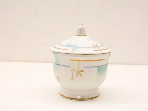 Elegant porcelain container with lid and gold accents, perfect for decorative displays and accents.