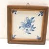 Rustic floral tile in wooden frame, perfect for charming wall decor in any home.