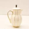 Elegant porcelain coffee pitcher with gold stripes, perfect for table decor and collection.