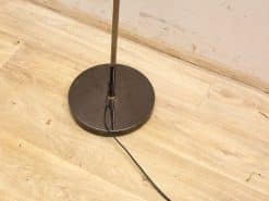 Sleek modern floor lamp with metallic design and warm wood base, perfect for ambient lighting.