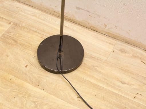 Sleek modern floor lamp with metallic design and warm wood base, perfect for ambient lighting.