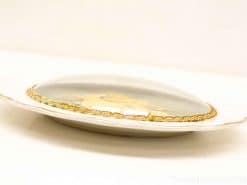 Elegant porcelain wall plate featuring a vintage ship sculpture and luxurious gold trim.