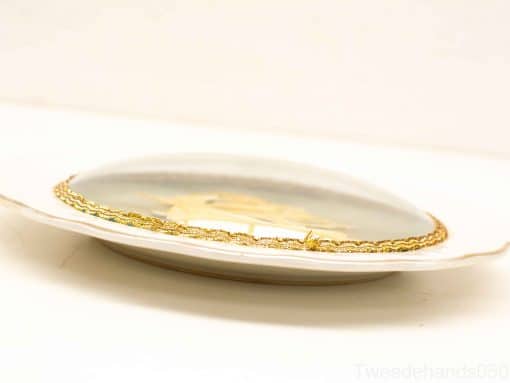 Elegant porcelain wall plate featuring a vintage ship sculpture and luxurious gold trim.