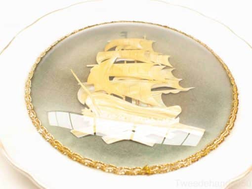 Elegant decorative plate featuring a detailed sailing ship against a grey-blue background.